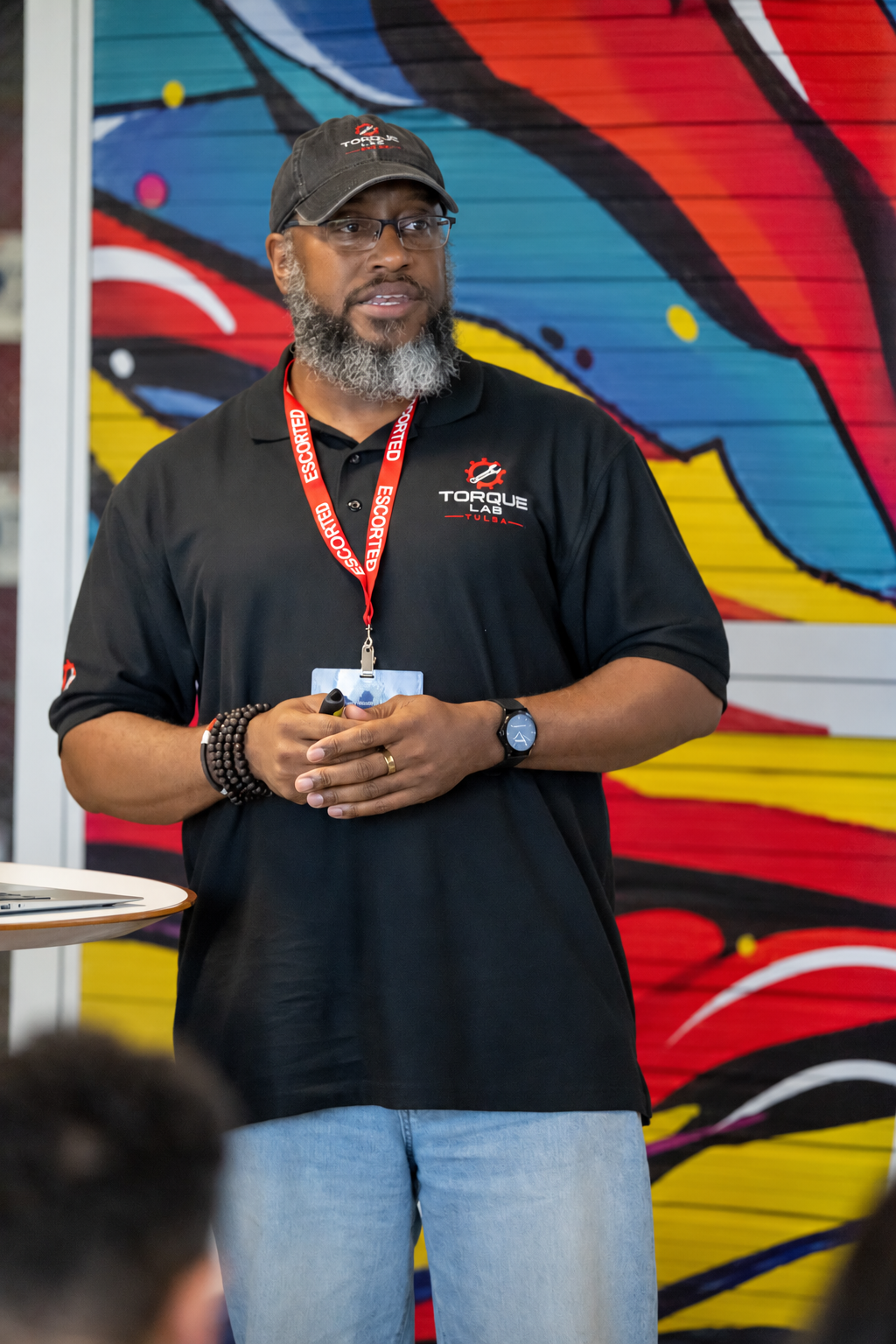 Sheldon F. Joseph, Founder of Torque Lab Tulsa, standing in front of a colorful mural